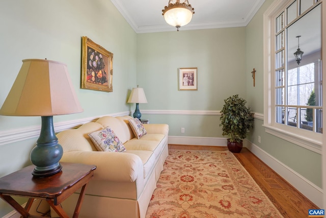 living area featuring light wood-type flooring and crown molding