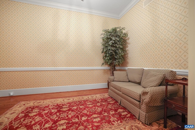 sitting room with ornamental molding and hardwood / wood-style floors