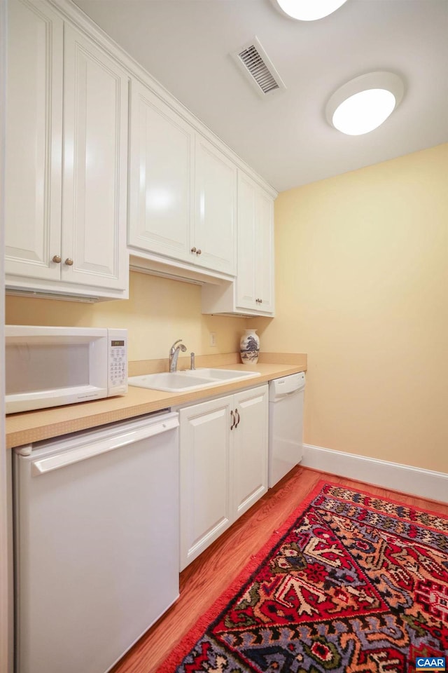 kitchen featuring white cabinets, white appliances, light hardwood / wood-style flooring, and sink