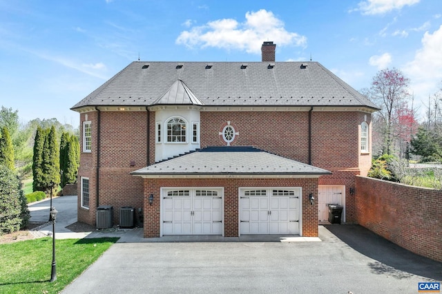 view of front of home featuring central air condition unit and a garage