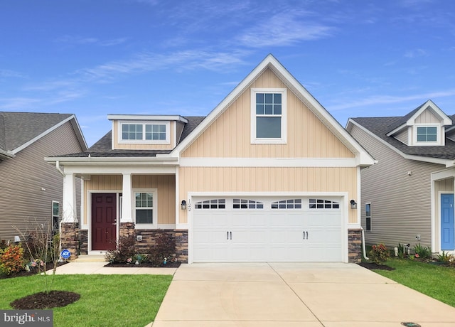 craftsman house featuring a garage, stone siding, board and batten siding, and concrete driveway