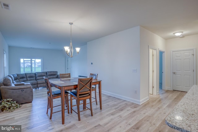 dining area featuring light hardwood / wood-style flooring and an inviting chandelier