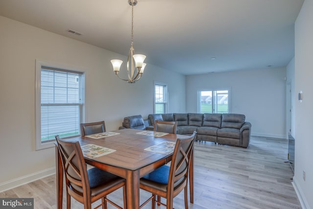 dining area featuring a notable chandelier and light hardwood / wood-style floors