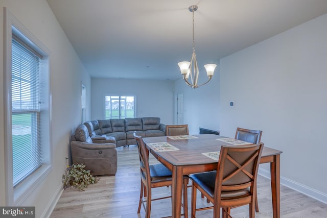 dining area with a notable chandelier and light hardwood / wood-style flooring