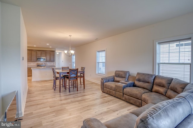 living room with an inviting chandelier and light hardwood / wood-style floors