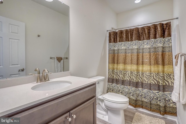 bathroom featuring hardwood / wood-style flooring, toilet, and oversized vanity