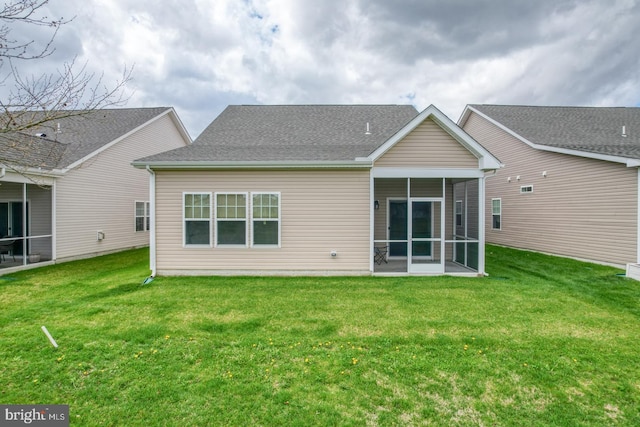 rear view of property with a sunroom and a lawn