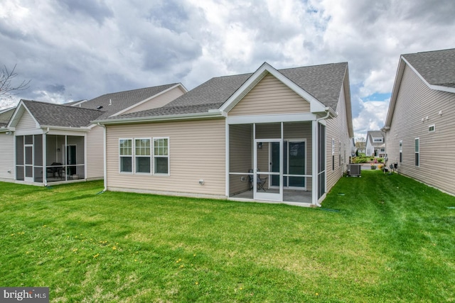 back of property with a sunroom, central AC, and a lawn