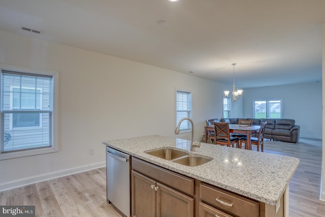 kitchen featuring an inviting chandelier, light hardwood / wood-style floors, stainless steel dishwasher, and sink