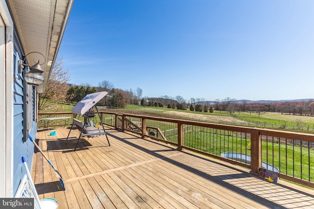 wooden deck with a lawn and a rural view