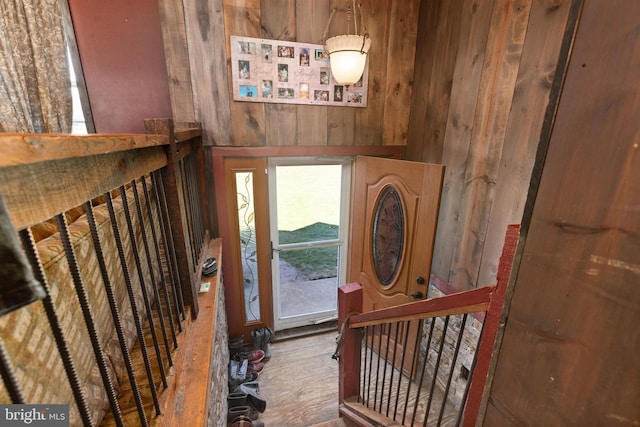 entryway with wooden walls and hardwood / wood-style floors