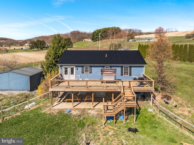 rear view of house featuring a lawn and a deck