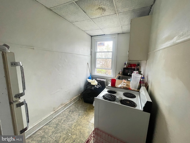 interior space featuring sink, a paneled ceiling, and light tile floors