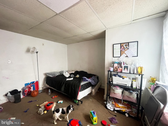 carpeted bedroom featuring a drop ceiling