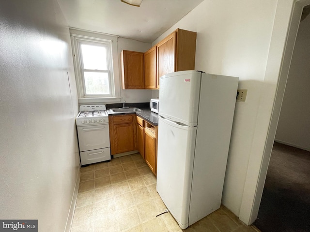 kitchen with sink, white appliances, and light tile floors