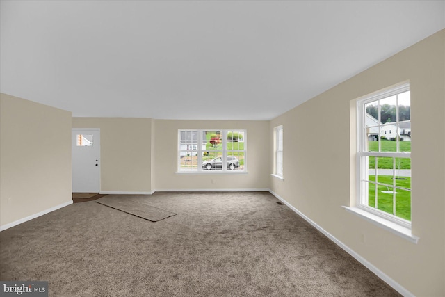 carpeted spare room featuring a wealth of natural light