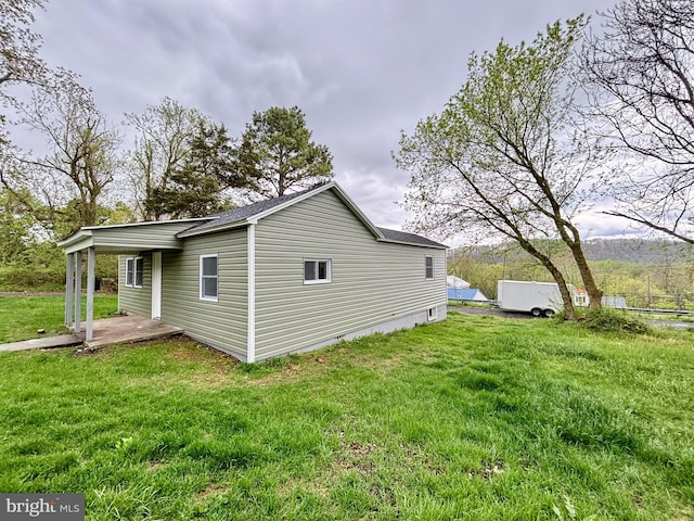 view of side of property featuring a yard and a patio