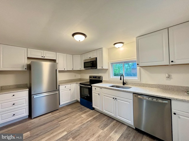 kitchen featuring light hardwood / wood-style floors, appliances with stainless steel finishes, and white cabinetry