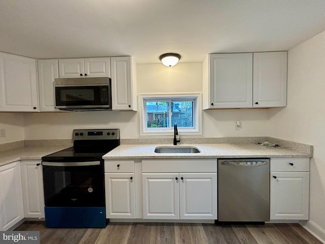 kitchen featuring dark hardwood / wood-style flooring, stainless steel appliances, white cabinetry, and sink