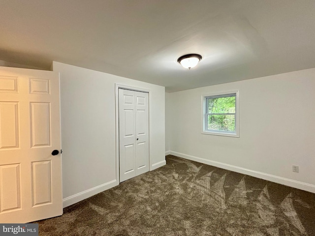 interior space featuring a closet and dark carpet