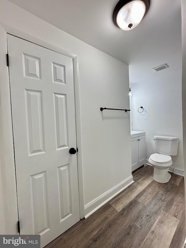 bathroom featuring vanity, hardwood / wood-style flooring, and toilet