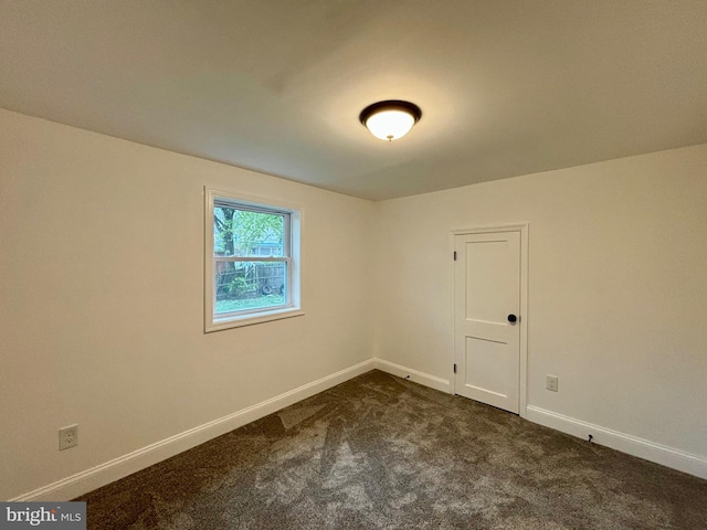 empty room featuring dark carpet