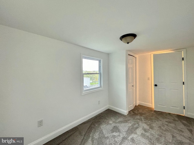 unfurnished bedroom with dark colored carpet