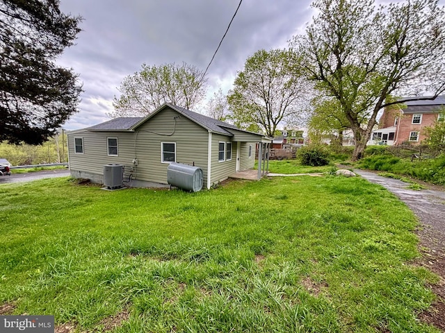 exterior space with central air condition unit and a lawn