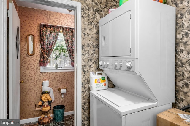 clothes washing area featuring stacked washer and dryer