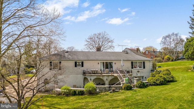 rear view of house featuring a deck and a lawn