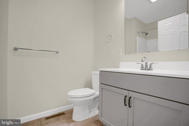 bathroom featuring walk in shower, vanity, tile patterned floors, and toilet