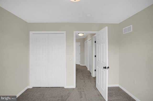 unfurnished bedroom featuring light carpet and a closet