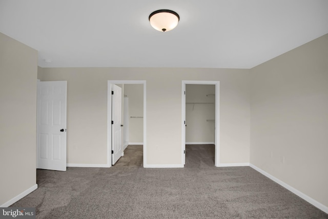 unfurnished bedroom featuring a walk in closet, carpet floors, and a closet