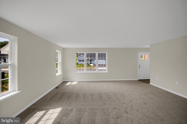 spare room featuring a healthy amount of sunlight and carpet