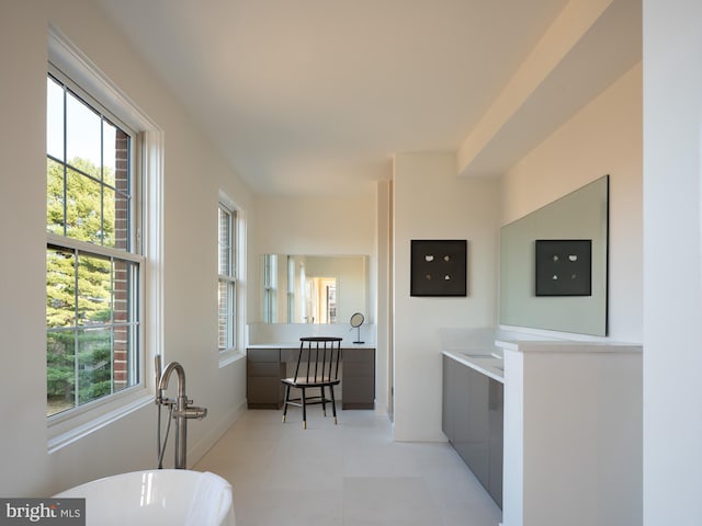 bathroom featuring tile floors, a washtub, and a healthy amount of sunlight