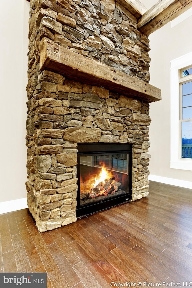 room details featuring dark hardwood / wood-style flooring and a stone fireplace