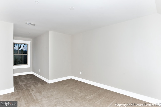 spare room with dark colored carpet