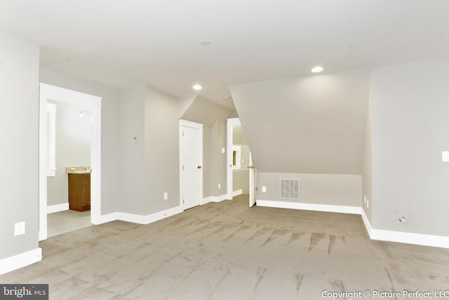 additional living space with lofted ceiling and light colored carpet