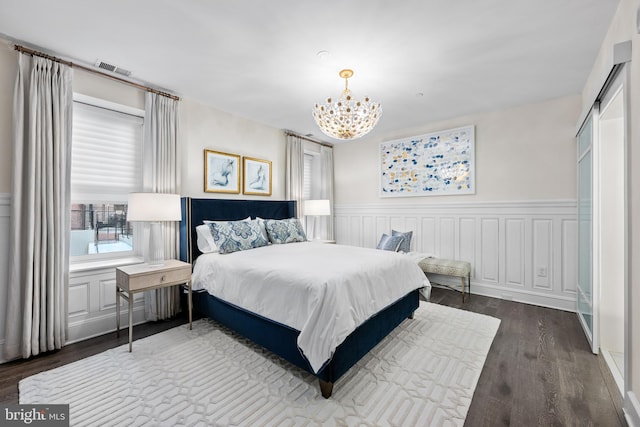 bedroom featuring dark hardwood / wood-style floors and an inviting chandelier