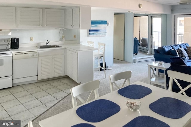 kitchen featuring baseboard heating, light carpet, white appliances, white cabinetry, and sink