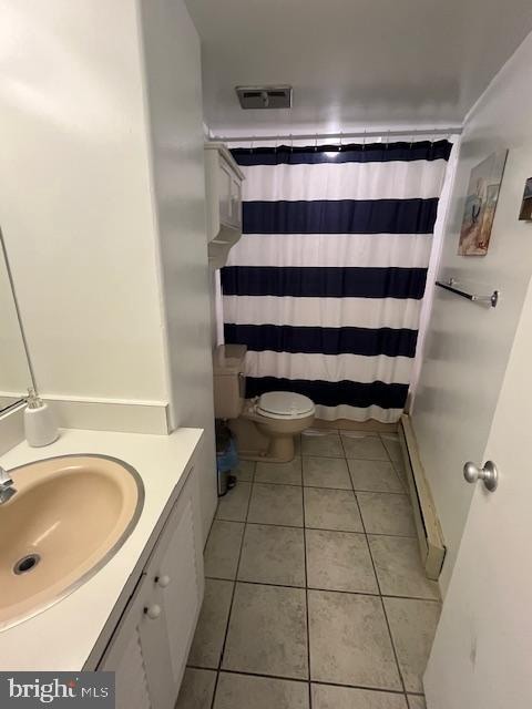 bathroom featuring baseboard heating, toilet, tile floors, and large vanity