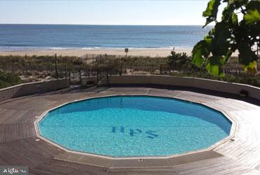 view of swimming pool with a beach view and a water view