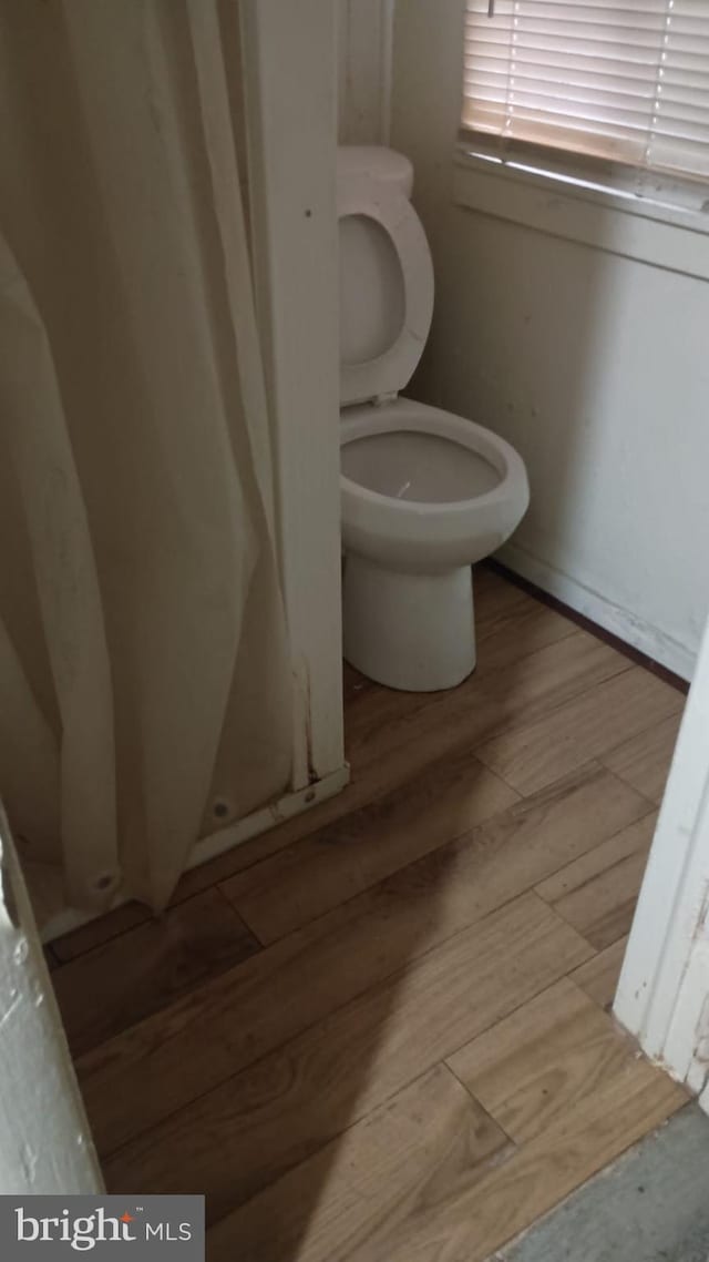 bathroom with toilet and hardwood / wood-style floors