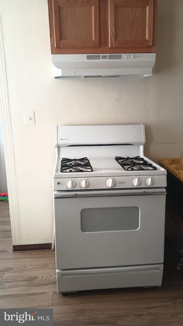 kitchen featuring gas range gas stove and dark hardwood / wood-style flooring