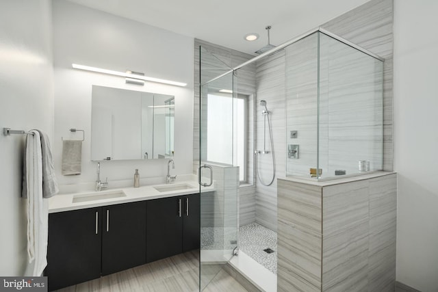 bathroom with an enclosed shower, dual sinks, and large vanity