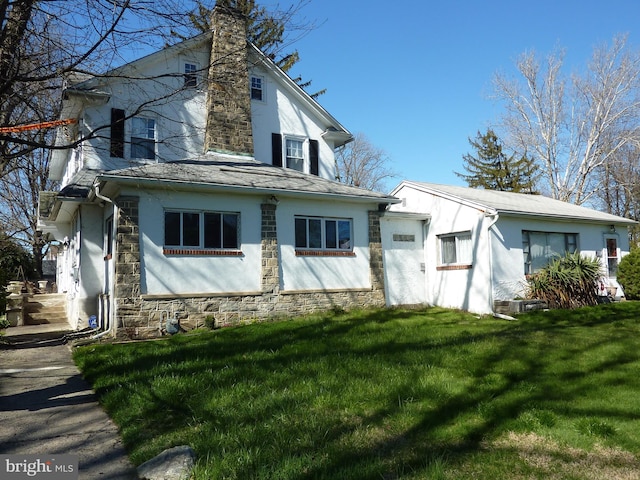 back of house featuring a lawn