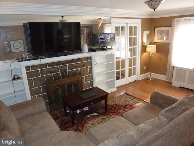 living room featuring hardwood / wood-style floors, crown molding, radiator heating unit, and a fireplace