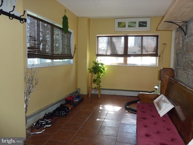 living area featuring dark tile floors and baseboard heating