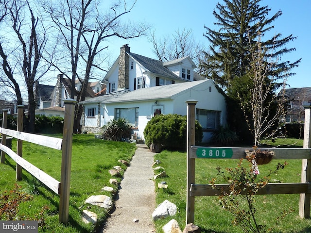 cape cod home with a front lawn