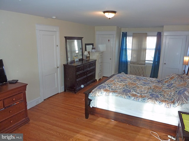 bedroom featuring radiator heating unit and hardwood / wood-style floors